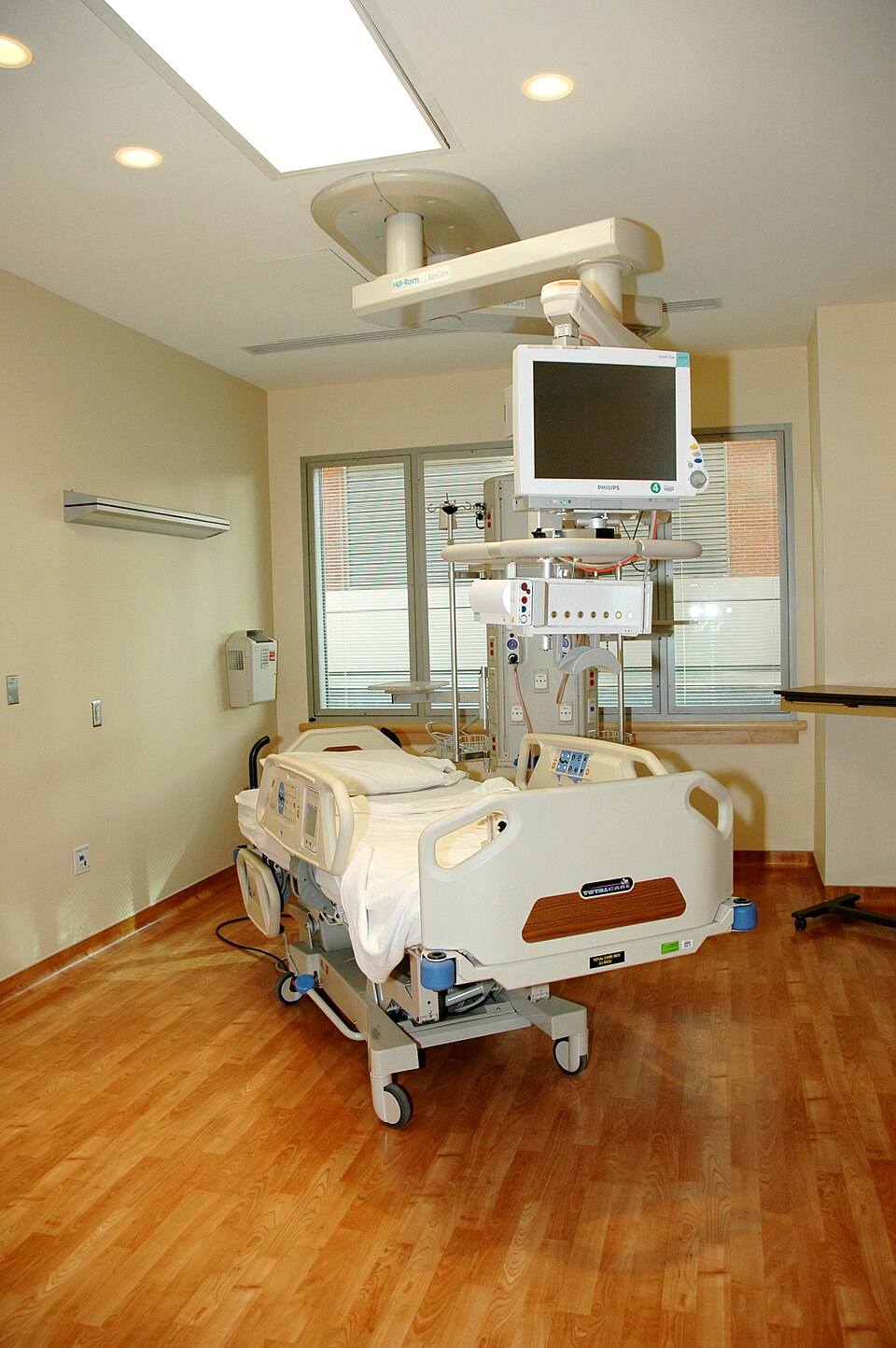 A single empty hospital bed in a patient room